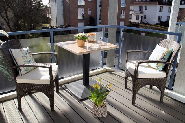 Südbalkon mit Tisch und Korbsesseln